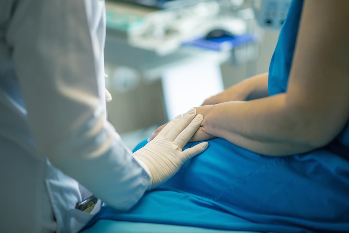 A clinician examining a patient in a treatment room.